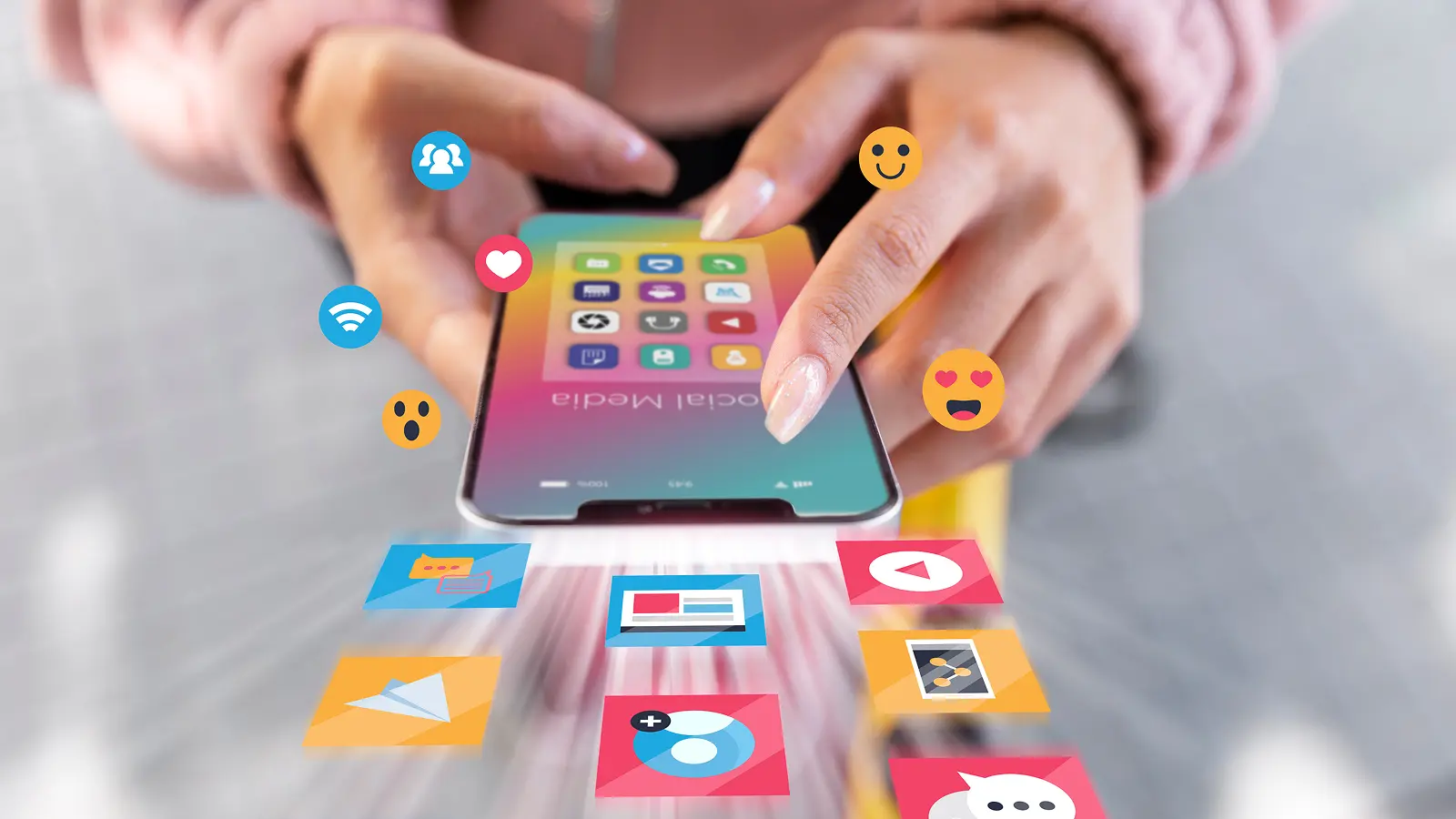 Person using a smartphone with social media app icons and emojis floating outward, representing engagement, messaging, and content sharing.