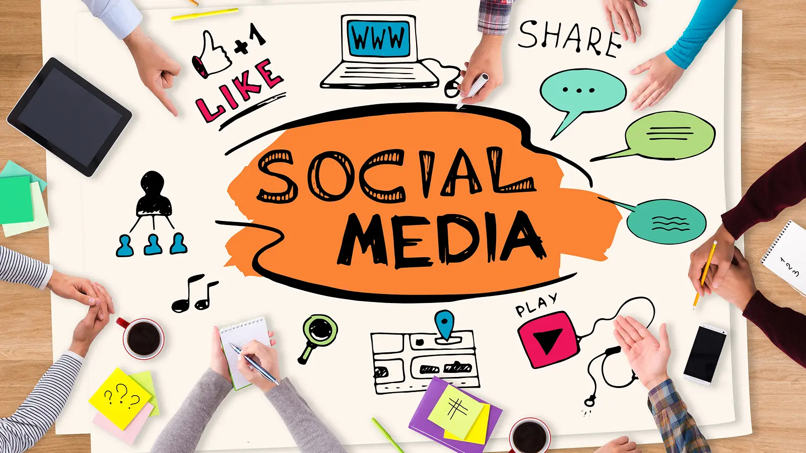 Top view of a creative brainstorming session with people planning social media strategies using icons like like, share, chat, play, and website.